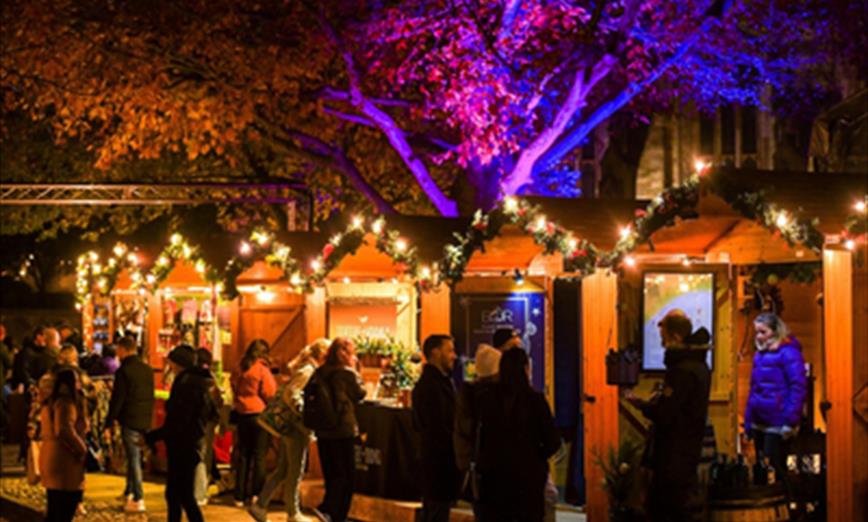 Winchester Cathedral Christmas market sheds and customers shopping