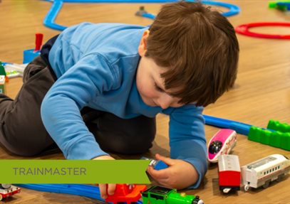 Young Toddler playing with toy train on tracks at October half term event held at Sky Park Farm.