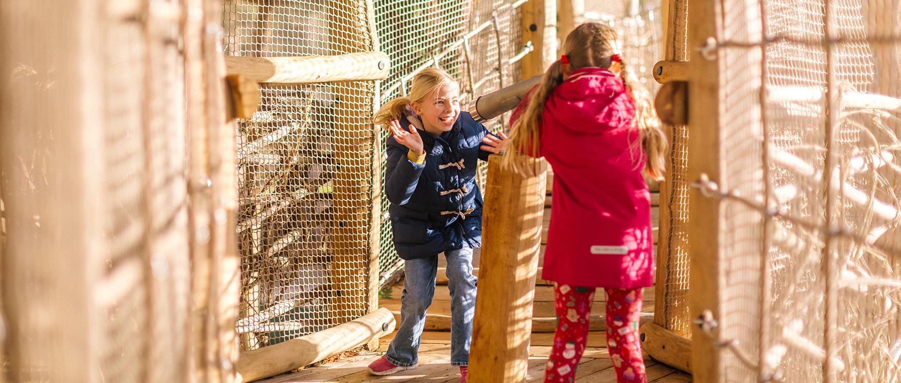 Two children play on the play area at Birdworld