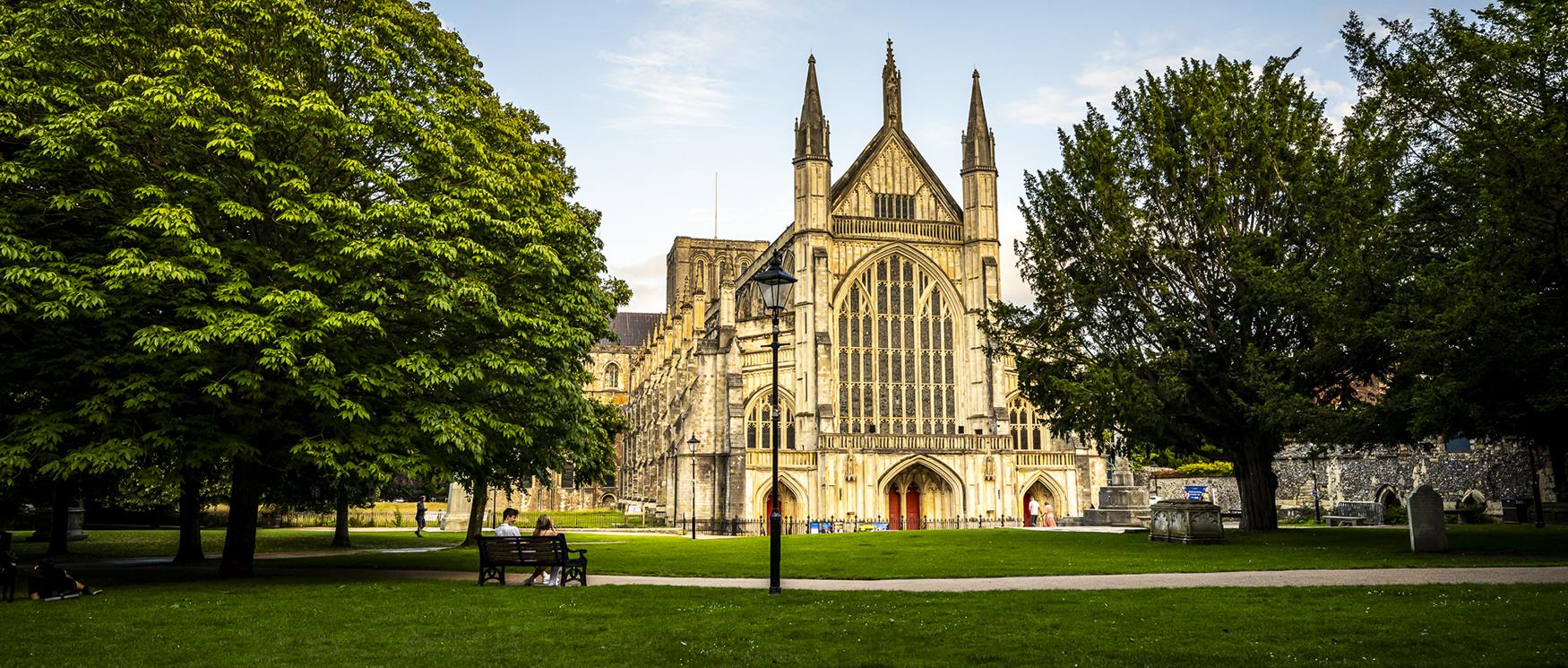 Winchester Cathedral on a sunny day, with its grand Gothic architecture, tall pointed arches, and intricate stonework, the final resting place of author Jane Austen.
