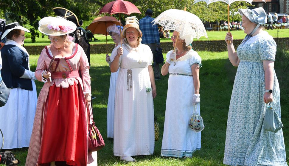 Ladies gathered on the 18th century lawn in Regency themed attire