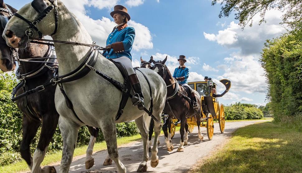 A post chaise carriage being pulled by a team of four horses