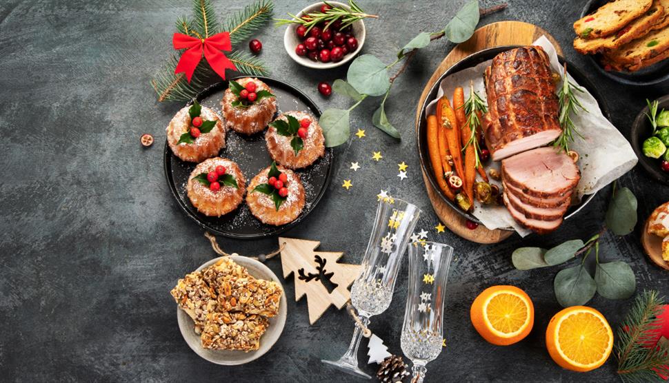 Festively decorated Christmas table with meat and side dishes with festive decor.