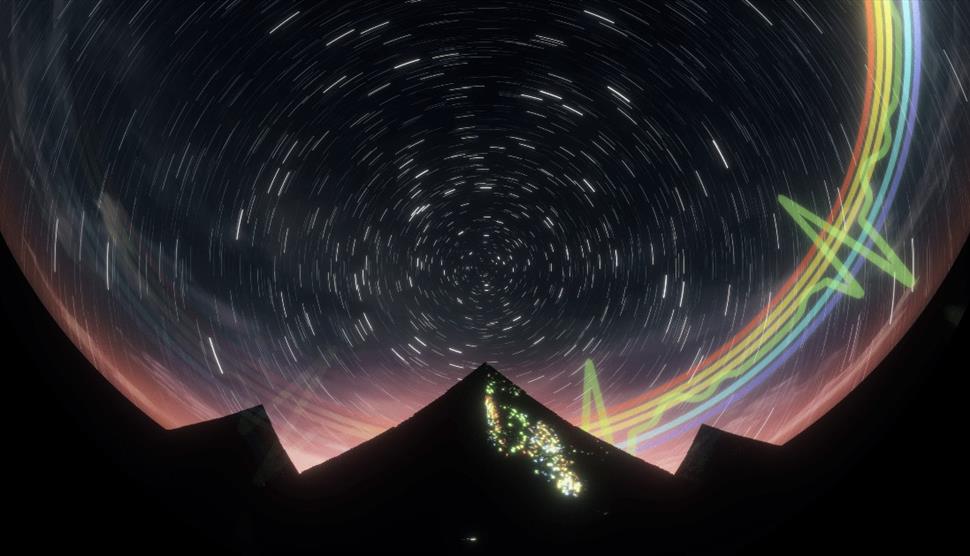 Visuals on a Planetarium dome. There is a mountain in silhouette and a rainbow in the background.