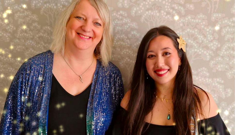 Two female singers with a sparkly background