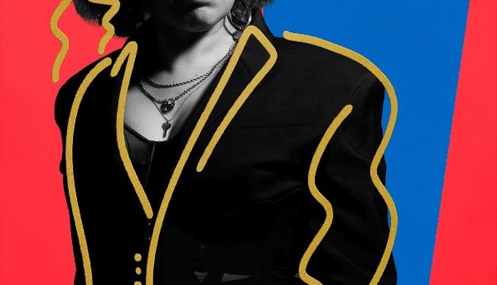 a woman who looks like Janet Jackson stands and stares at the camera, surrounded by bright colours and lines.