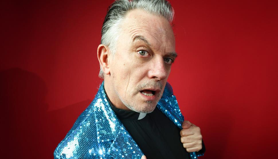 A man in a blue sequin jacket - Joe Rooney - is mugging for the camera