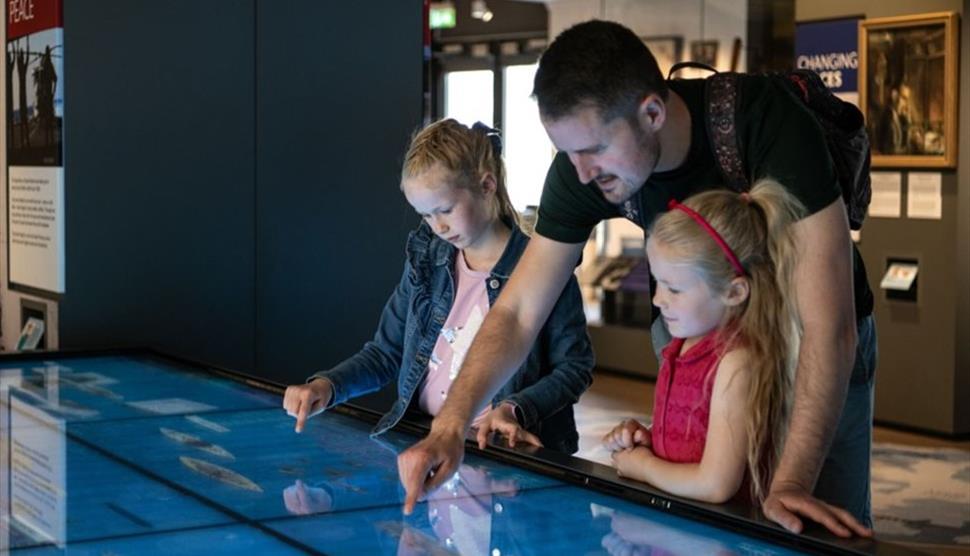 A family looks at an exhibit at the National Museum of the Royal Navy