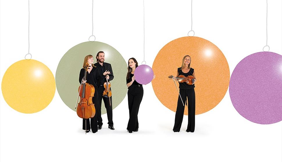 Members of the Bournemouth Symphony Orchestra with their instruments and a background of Christmas baubles