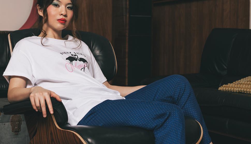 Belle Chen looks towards the camera as she leans back on a black leather chair.