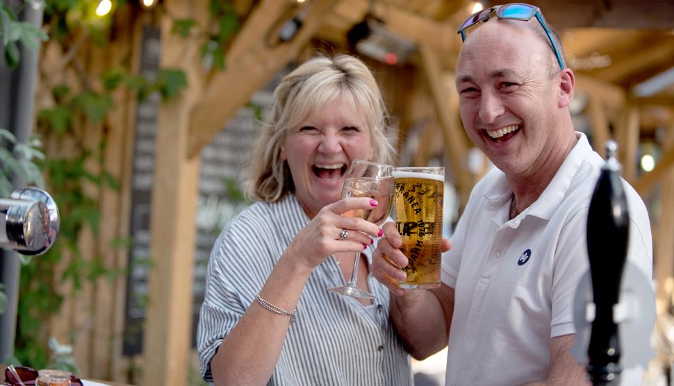A couple enjoy drinks at Back of Beyond Touring Park