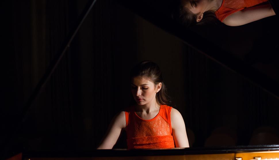 Cordelia Williams sits looking down at the piano.