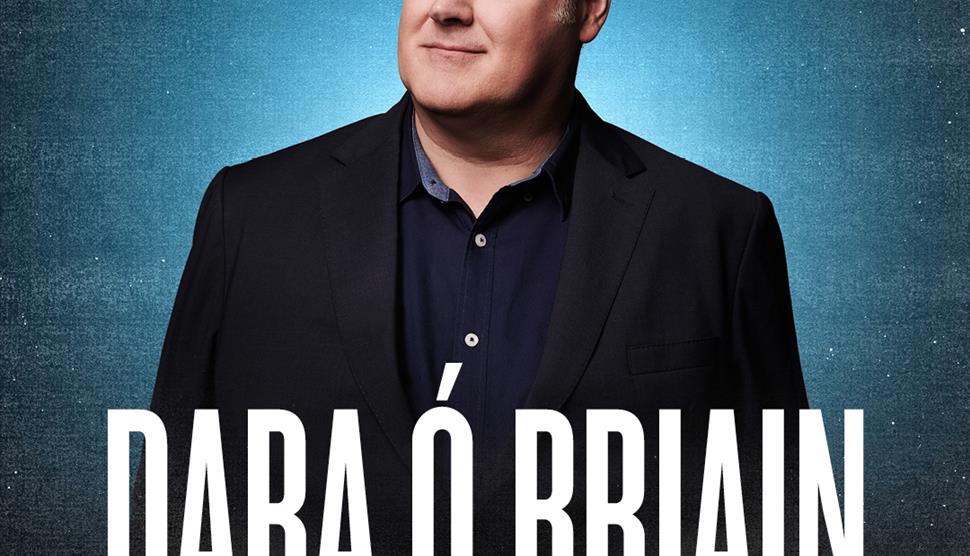 Dara Ó Briain in front of blue background