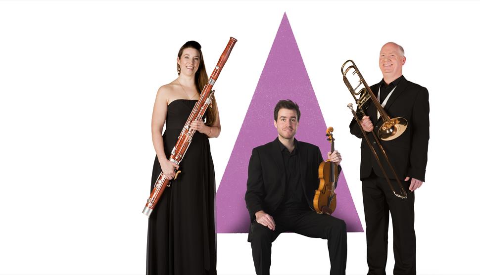 Three musicians are holding their instruments in front of a purple triangle graphic.