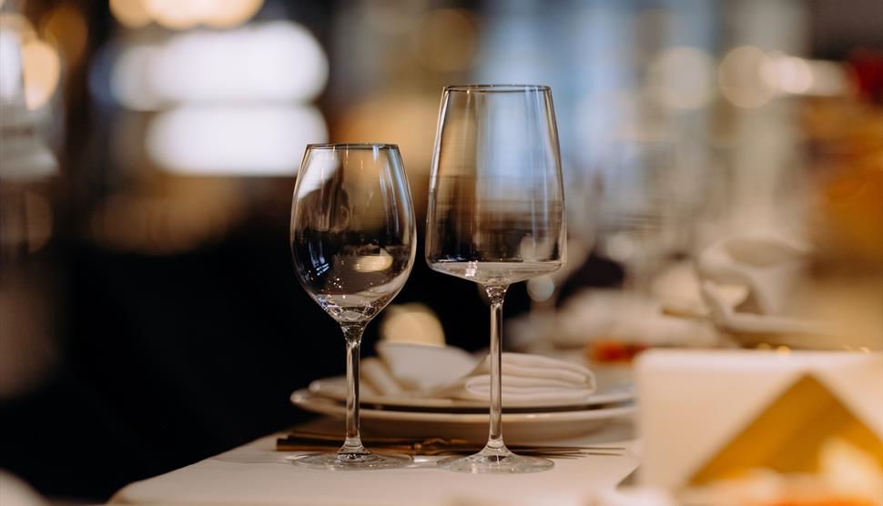 Two wine glasses sat on a neatly set table