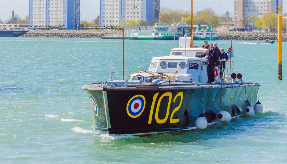 High Speed Launch 102 cruising across Portsmouth Harbour, a classic WWII rescue vessel cutting through the water with a low, sleek profile.