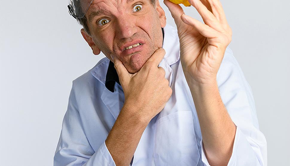 Henning Wehn wearing science goggles holding a lemon