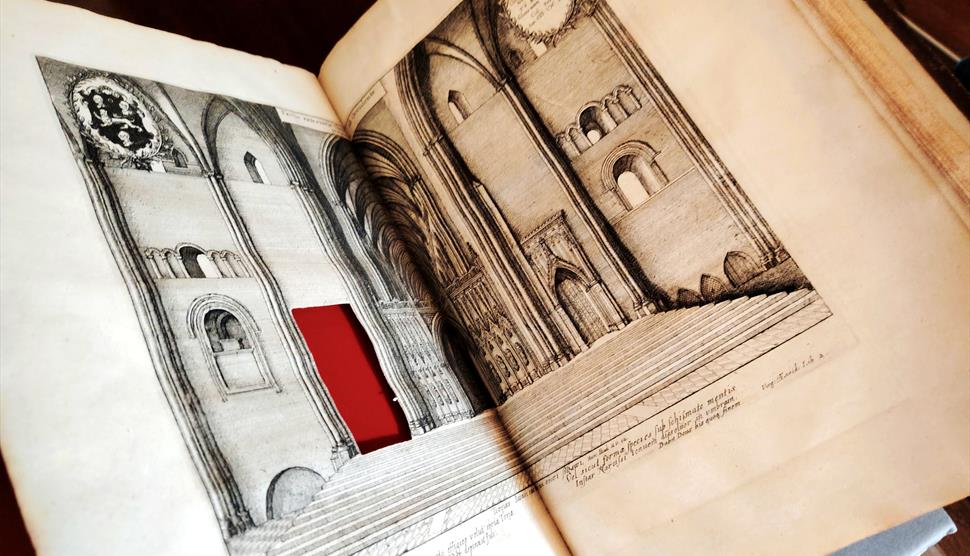 A book lies open revealing a section cut from the page.