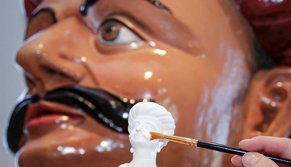 Photograph of a 3D printed miniature and the figurehead on which it was based.