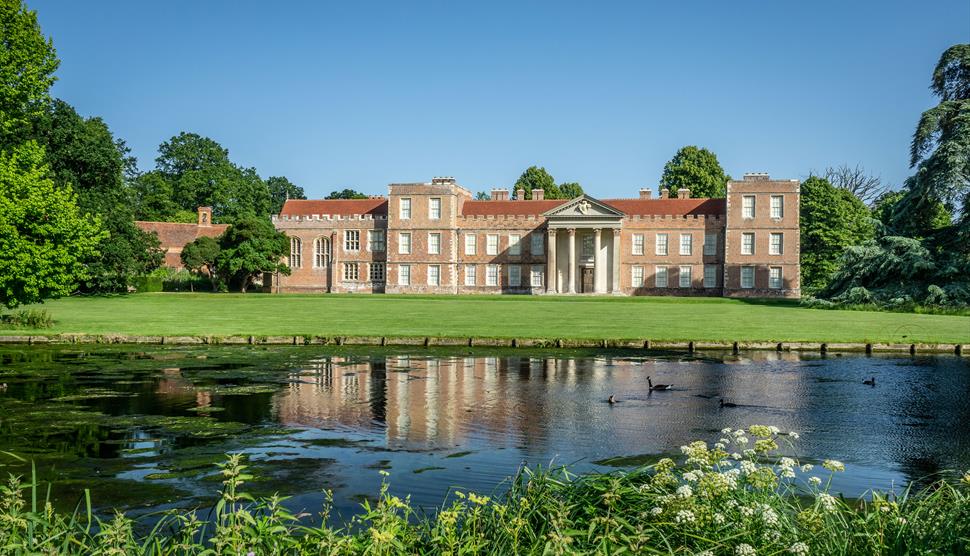 A view of The Vyne house and north lawn from across the lake.