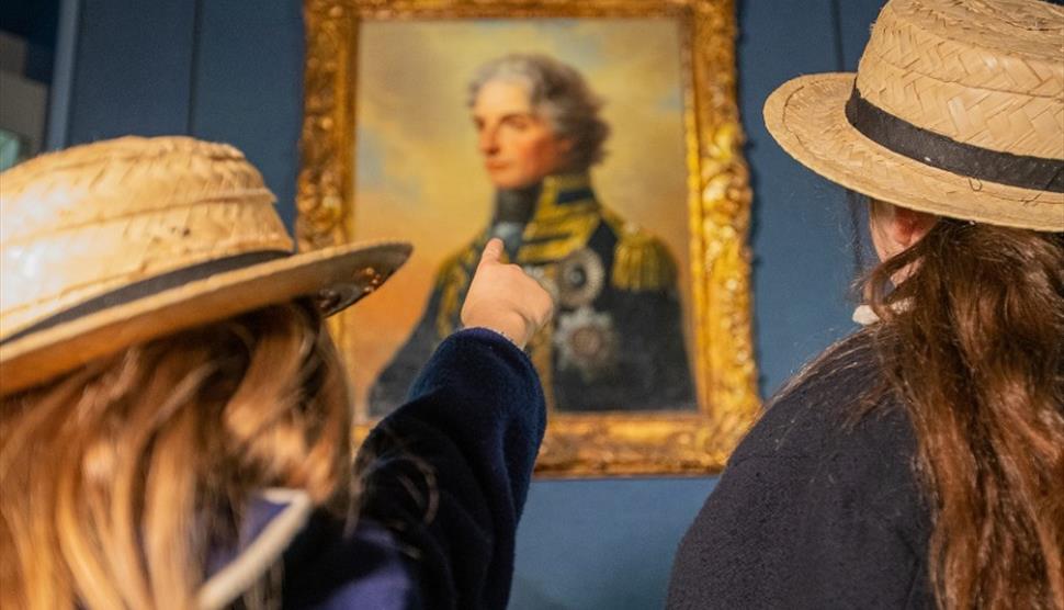 Children taking in a painting of Nelson at Portsmouth Historic Dockyard