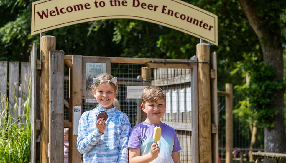 Two children enjoying an ice cream outside the deer encounter walk through area