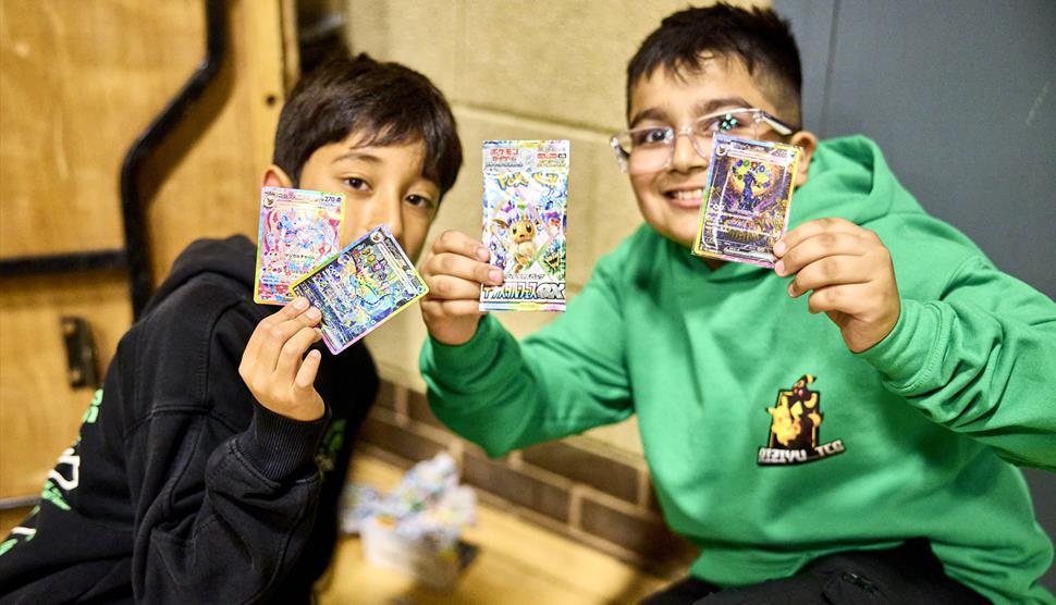 Children opening Pokemon packs at a card show