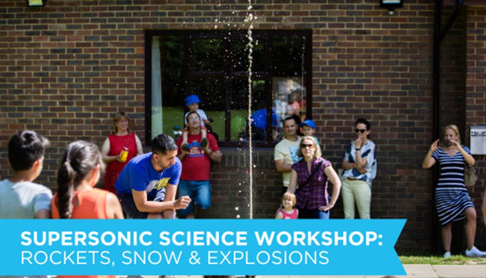 Children watching with awe at a science workshop demonstration of Mentos and Fizzy drinks explosion effect, outdoors.