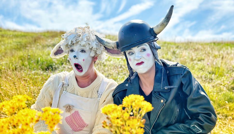 Two clowns, one dressed as a cute sheep and the other dressed as a biker cow!