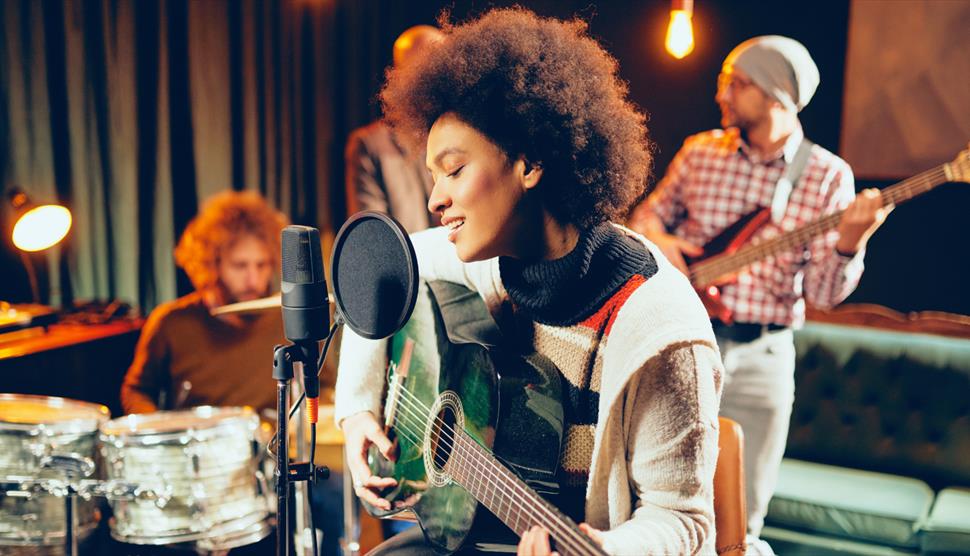 A woman singing with people in the background