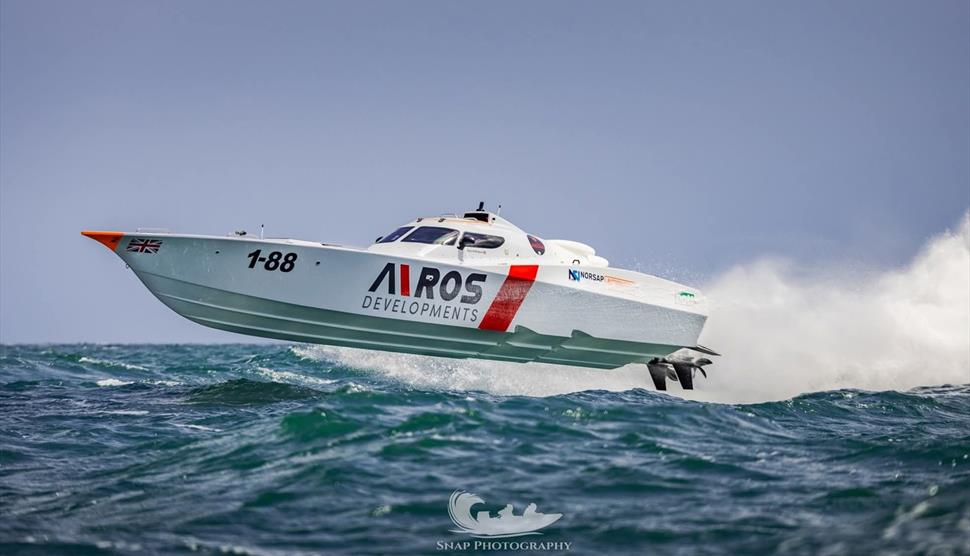 Photograph of a boat racing over the water - by Snap Photography
