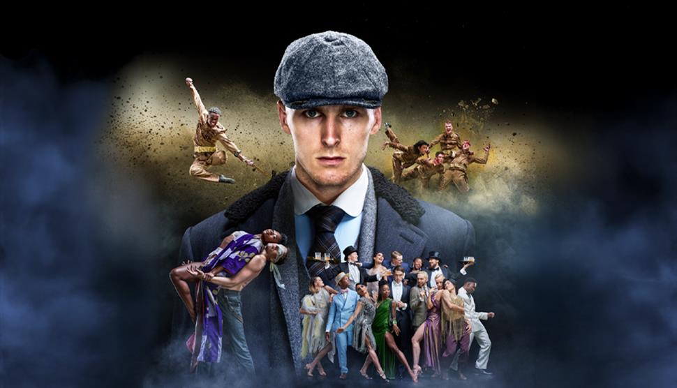 Man in flat cap in centre with dancers around him dressed as World War 1 soldiers