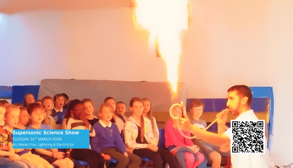 Science Teacher demonstrating a Fire Experiment to a group of seated Children