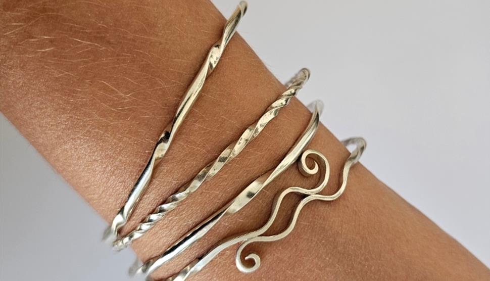 Set of decorative silver stacking bangles on wrist