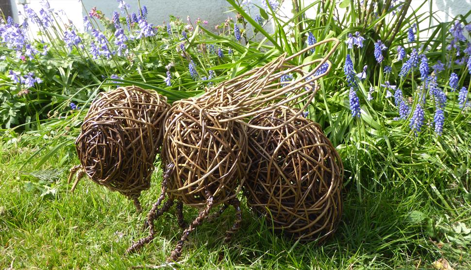 Willow bee sculpture sitting on grasss