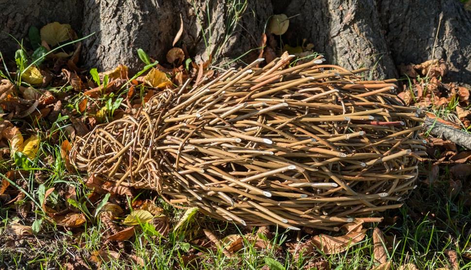 Willow hedgehog sculpture in front of a tree