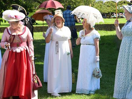 Ladies gathered on the 18th century lawn in Regency themed attire