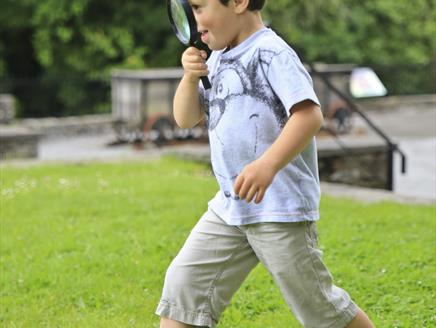 A child looking through a magnifying glass
