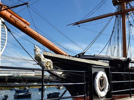 The exterior of HMS Warrior with the Spinnaker Tower in the distance