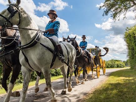 A post chaise carriage being pulled by a team of four horses