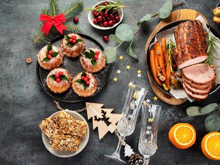 Festively decorated Christmas table with meat and side dishes with festive decor.