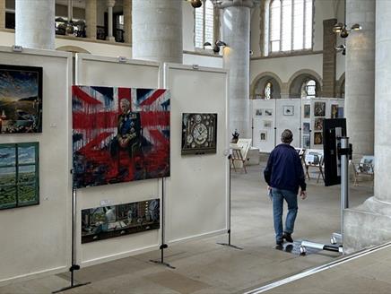 A man walking round an art exhibition at Portsmouth Cathedral.