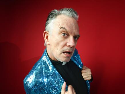 A man in a blue sequin jacket - Joe Rooney - is mugging for the camera