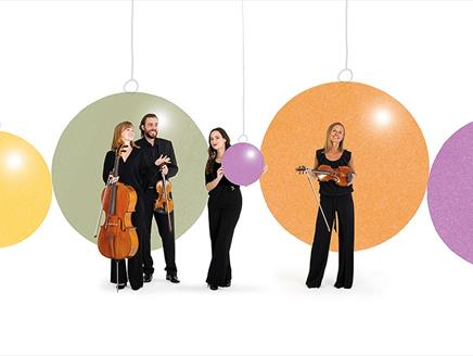 Members of the Bournemouth Symphony Orchestra with their instruments and a background of Christmas baubles