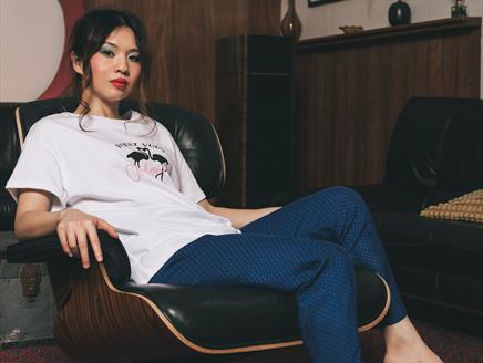 Belle Chen looks towards the camera as she leans back on a black leather chair.