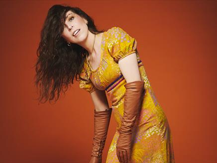 Bridget Christie in a gold dress for the promotional shot of her latest tour: Jacket Potato Pizza
