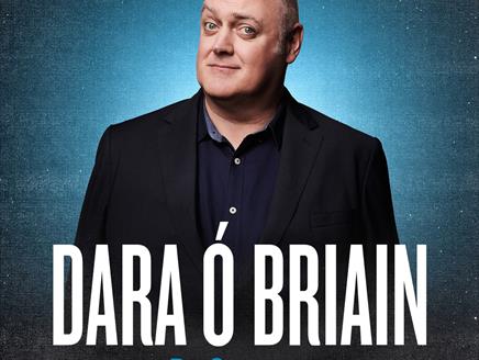 Dara Ó Briain in front of blue background