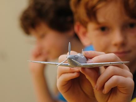 Boy at The D-Day Story showing off an Airfix model of an aeroplane - credit Matt Scott-Joynt