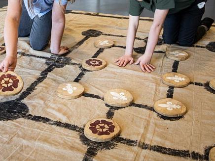 A Tudor board game laid out in cloth with large wooden counters
