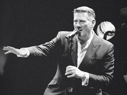 Black and white photograph of Tony Hadley mid-performance